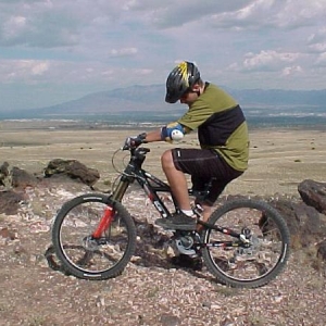 me on the bike at the volcanoes with the sandia mountains of albuquerque in background