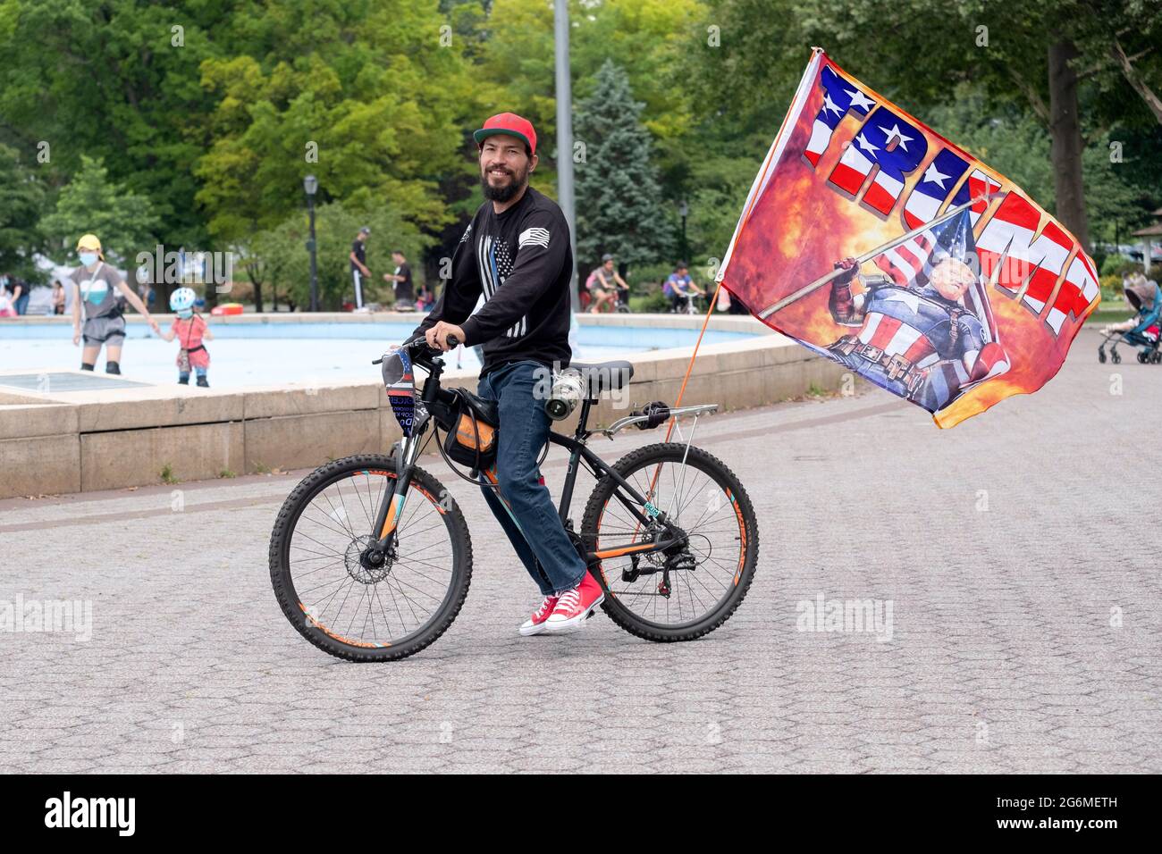 a-dominican-american-trump-supporter-rides-his-bike-displaying-a-large-trump-banner-near-the-u...jpg