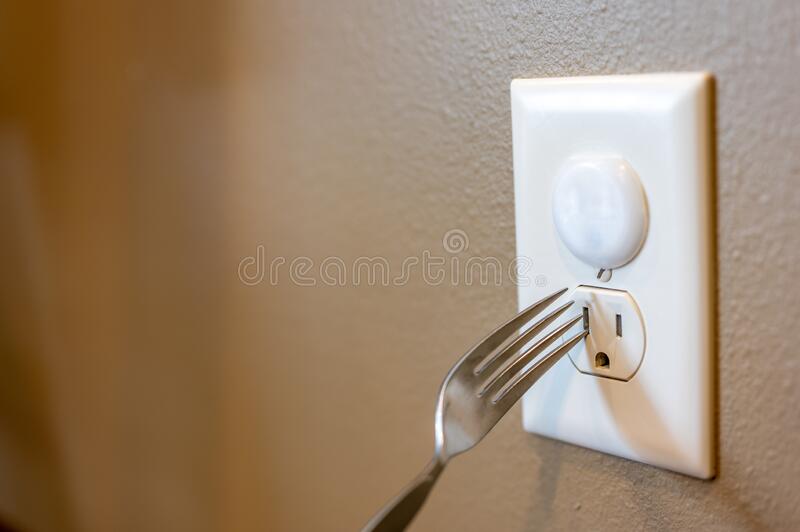 selective-focus-edge-metal-fork-to-be-inserted-open-electrical-outlet-socket-top-has-plastic-c...jpg