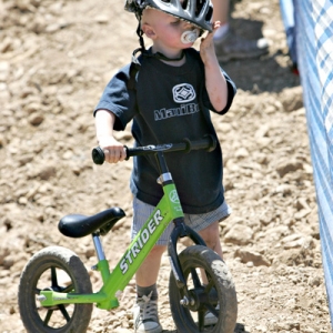 Future cyclist cleaning himself off after hitting the deck.