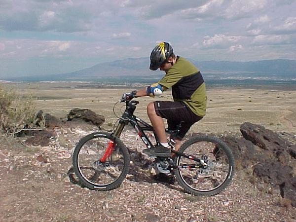 me on the bike at the volcanoes with the sandia mountains of albuquerque in background